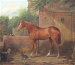 Portrait of a chestnut horse outside a stable with two terriers